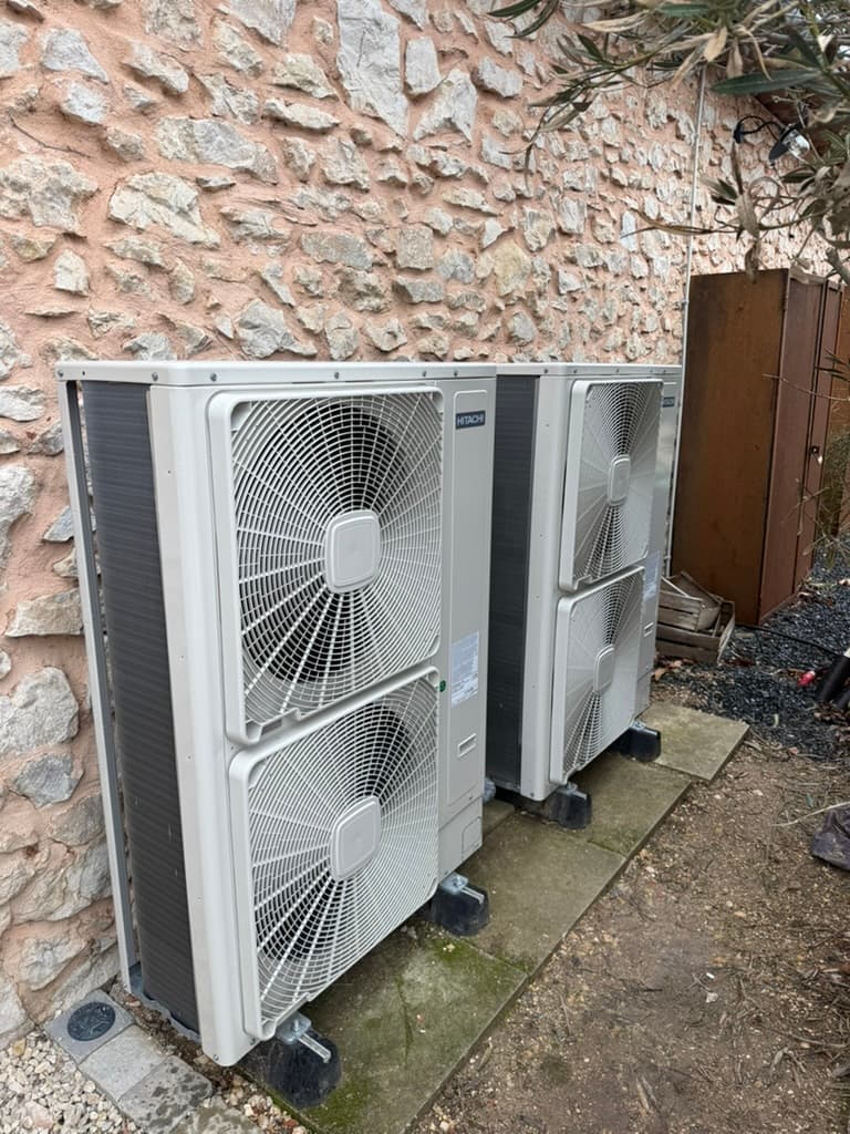 Double groupe extérieur Hitachi installé sur mur en pierre — configuration multi-split
