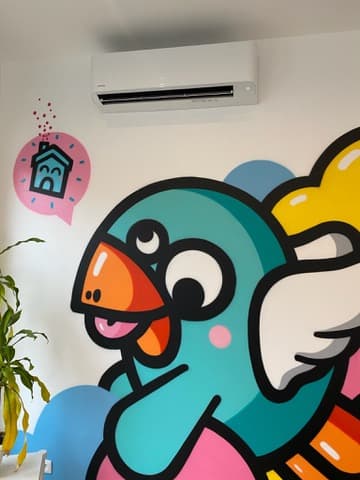 Mono-split Toshiba dans une chambre d'enfant — pose haute, intégrée au-dessus d'une fresque murale